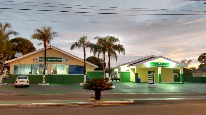 Fachada da Santa Casa de Quintana ao entardecer, com a entrada do Pronto Atendimento à esquerda e o Centro de Especialidades Odontológicas à direita, entre palmeiras.